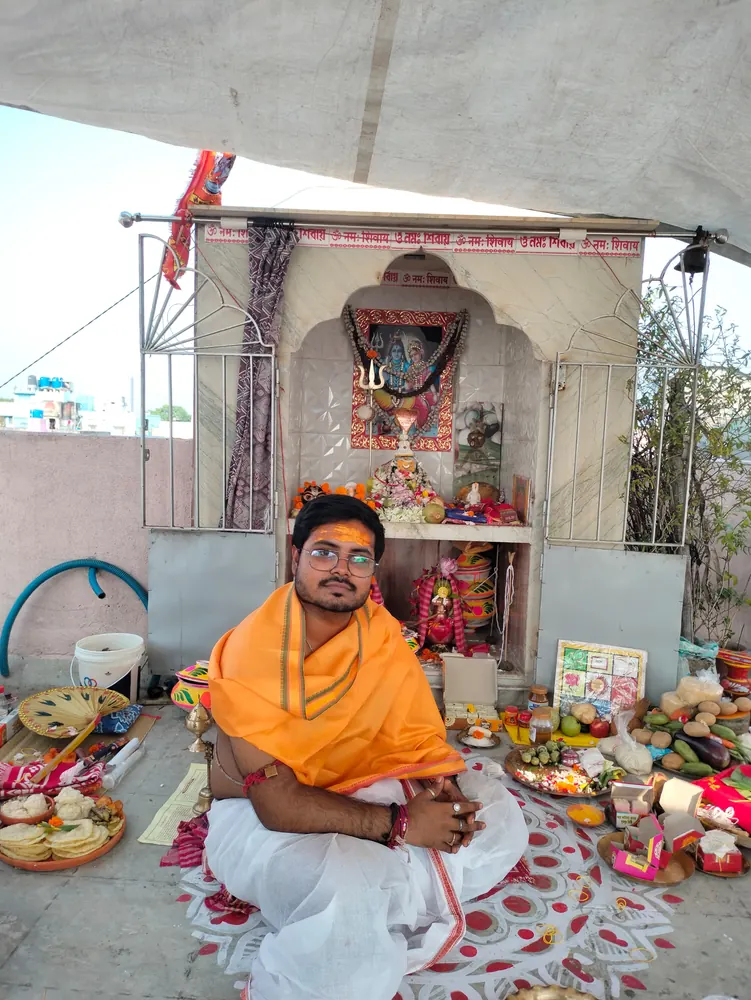 Purohit Rohit Chakraborty seated at a puja